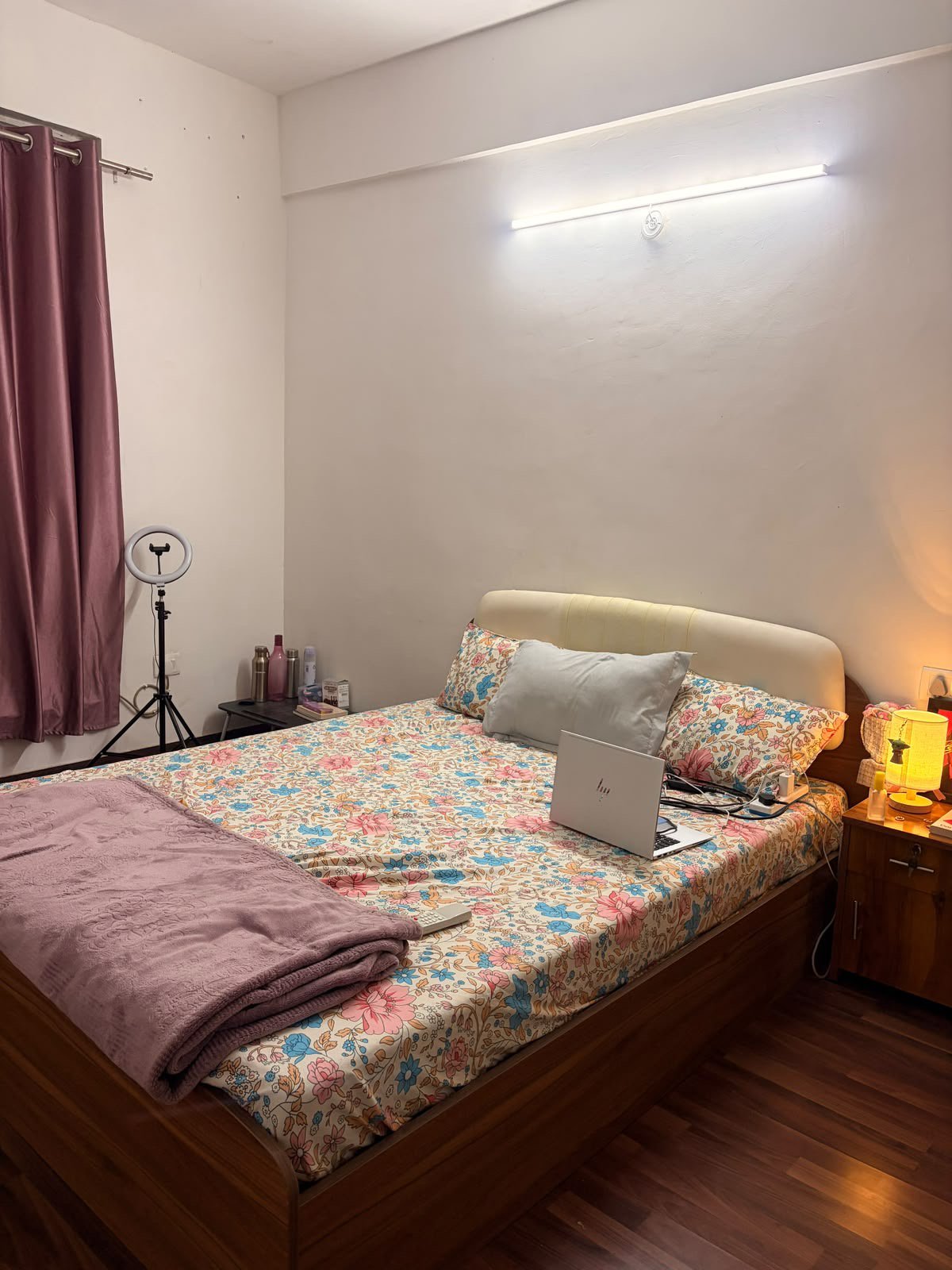 Cozy furnished bedroom with desk and bedside lamp