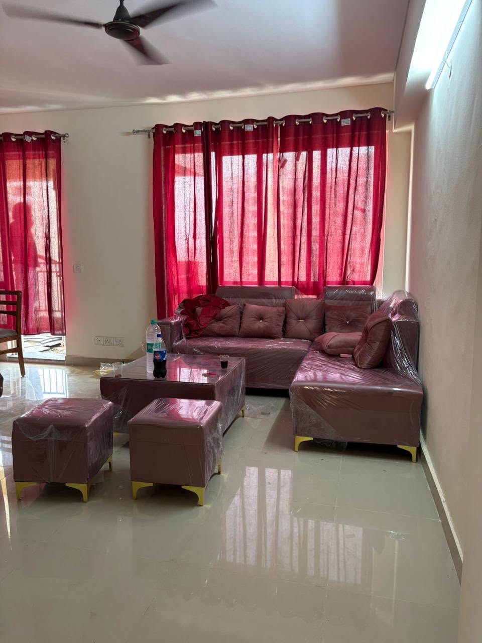 Furnished living room with L-shaped sofa and balcony view