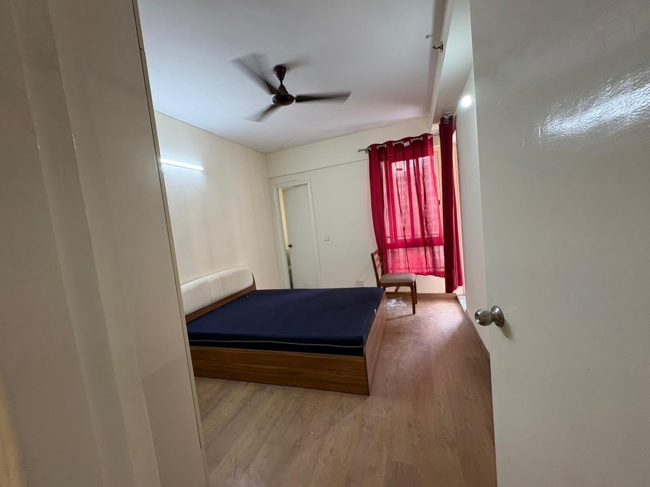 Room entrance view with wooden flooring and curtains