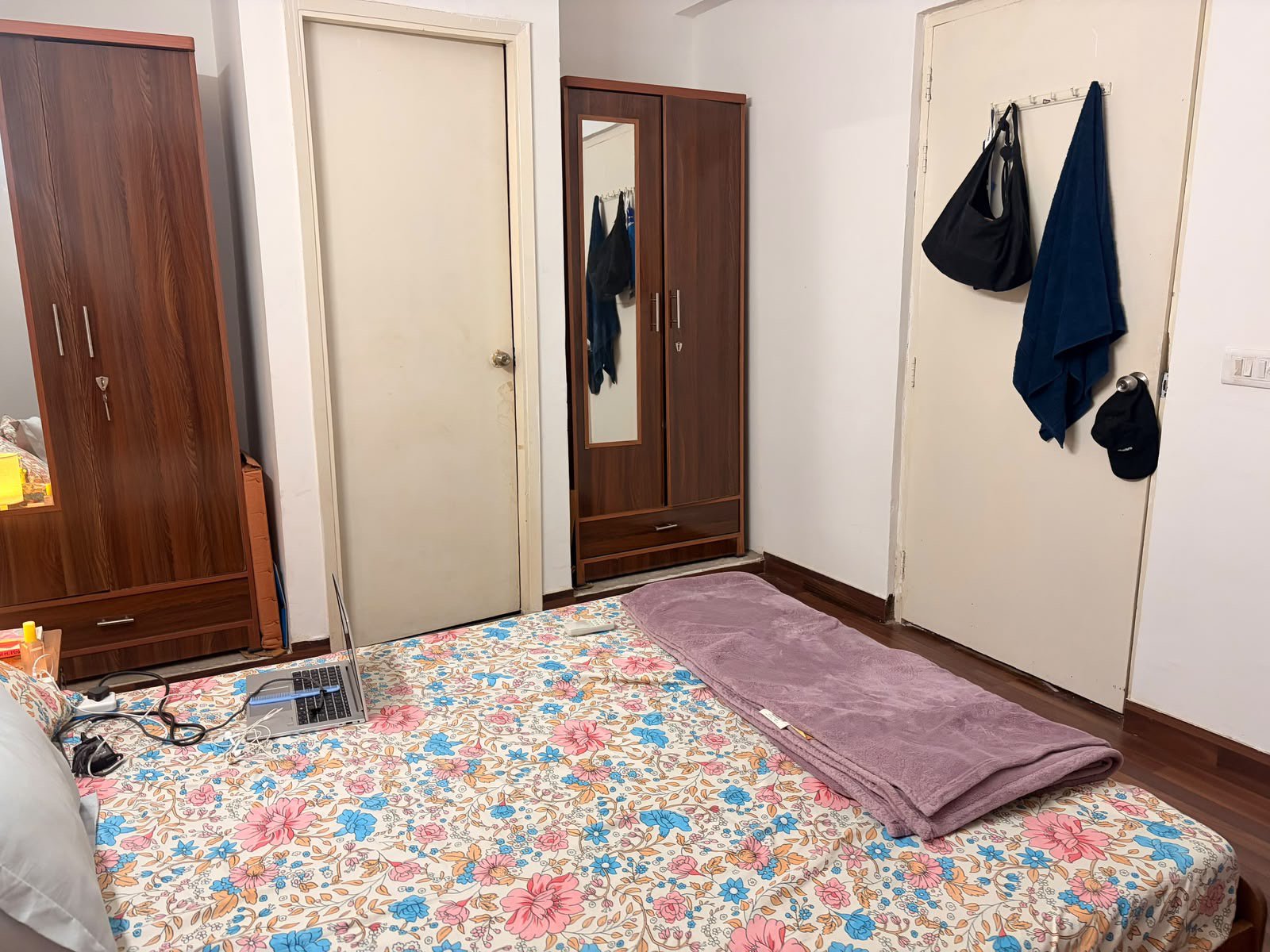 Wide view of furnished bedroom with twin wooden wardrobes