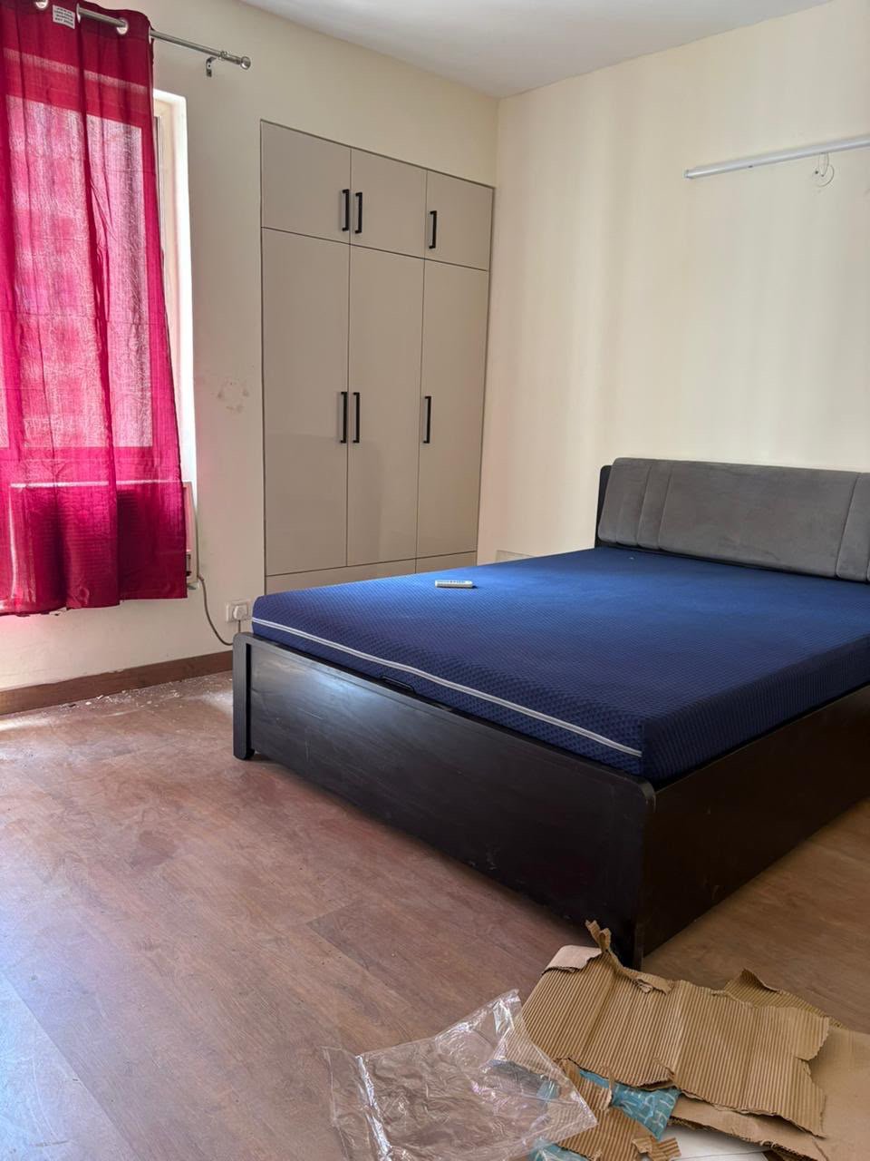 Furnished bedroom with blue mattress and wardrobe